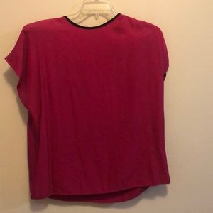 Bright pink blouse with black trim.